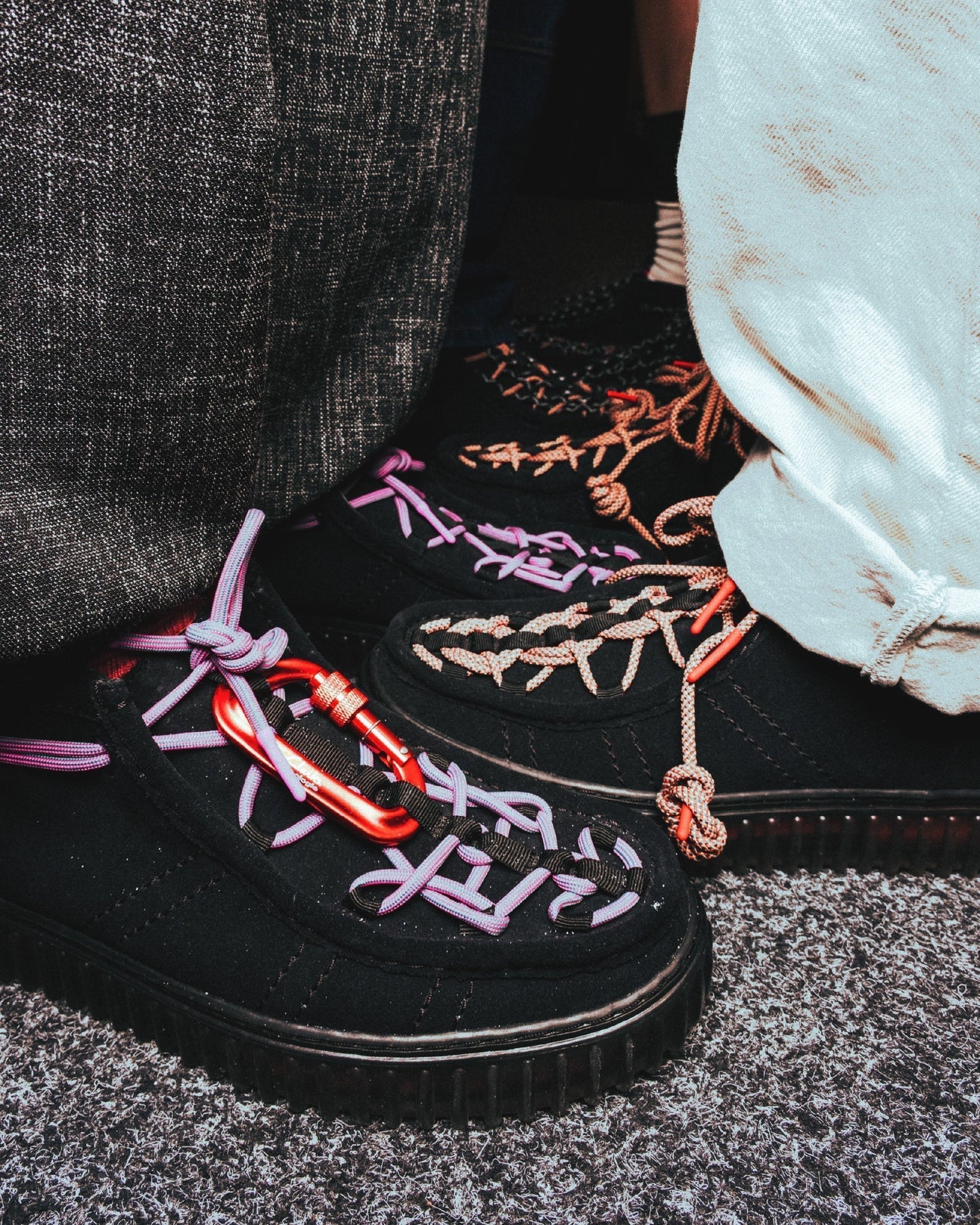Detalle de las Clarks Originals x Topologie Torhill Hi Black Interest en ante negro, con cordones técnicos violetas y mosquetón rojo de climbing