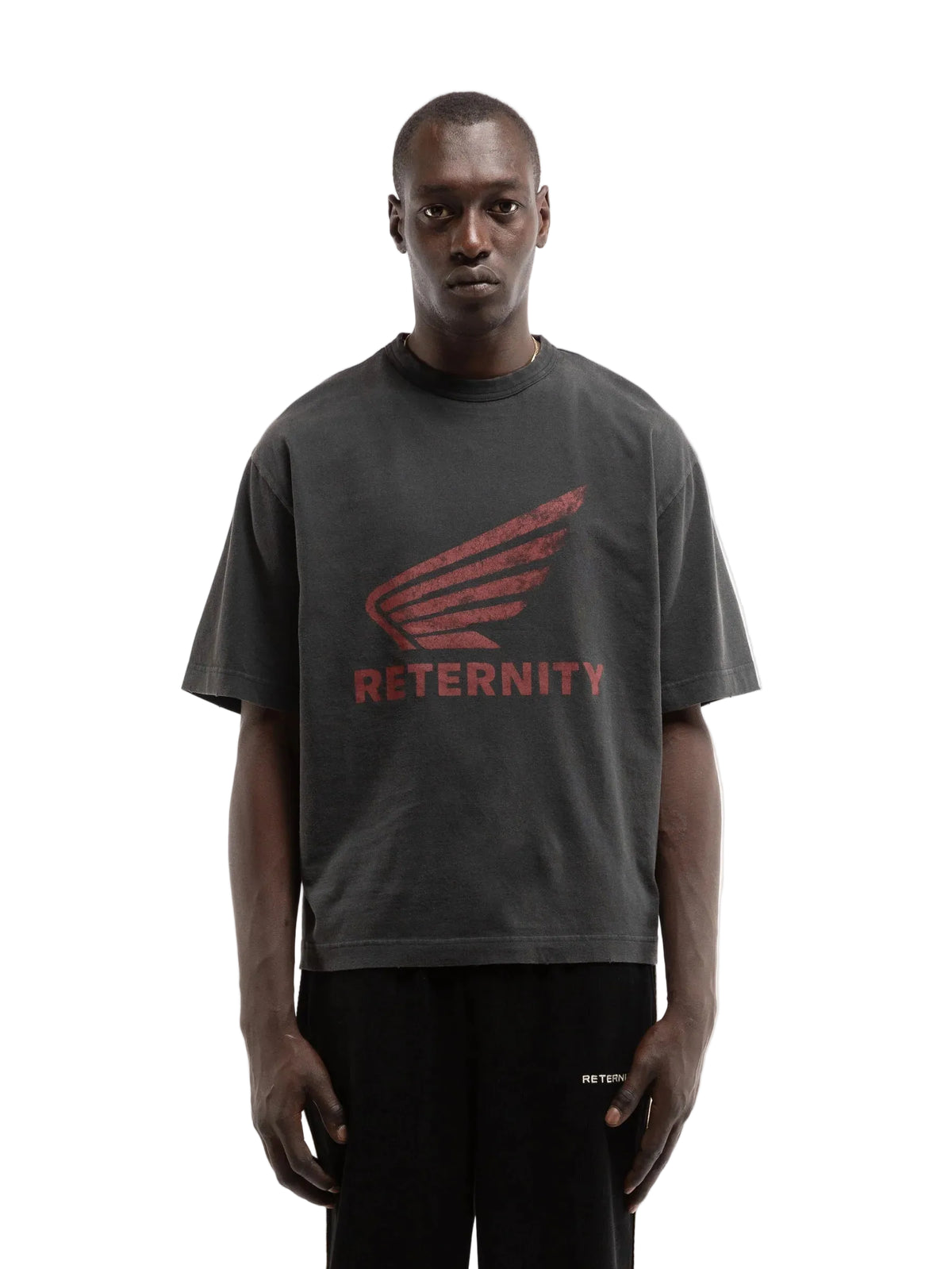 Hombre con la camiseta Reternity Aéro negro lavado y pantalón oscuro, look completo de cuerpo entero