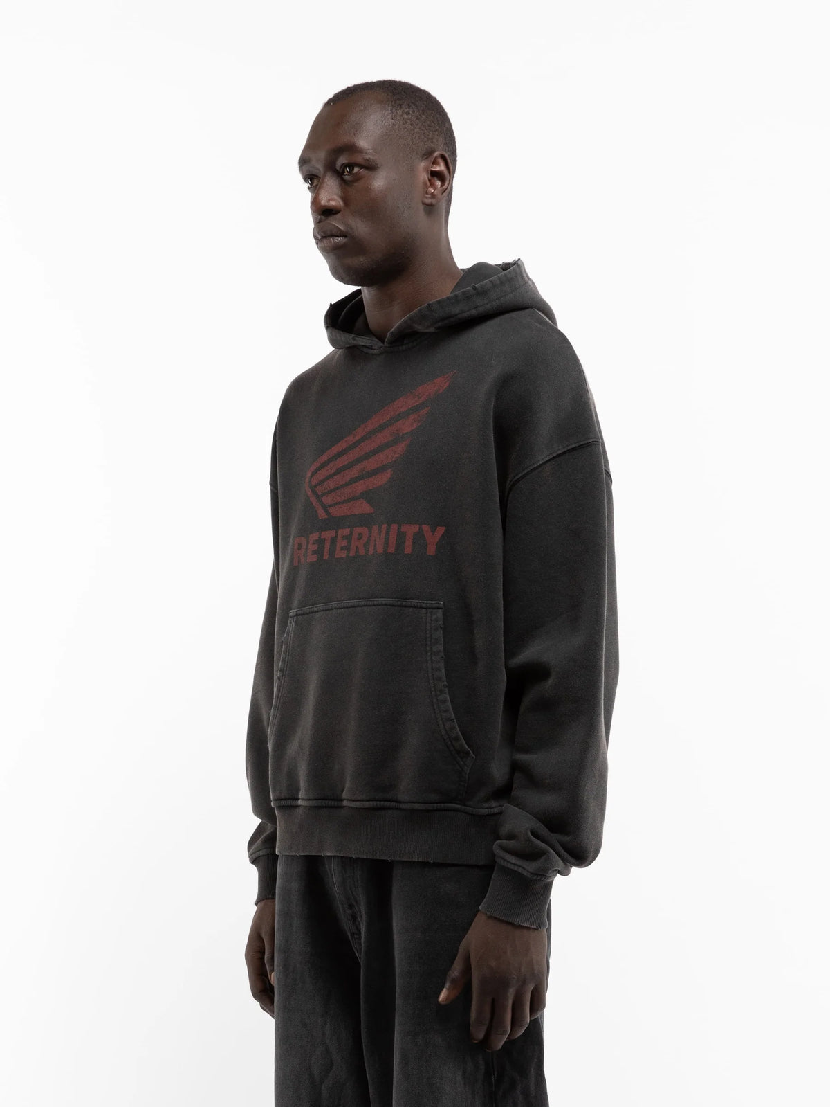 Hombre de perfil con la sudadera con capucha Reternity Aéro negro lavado, cuerpo entero