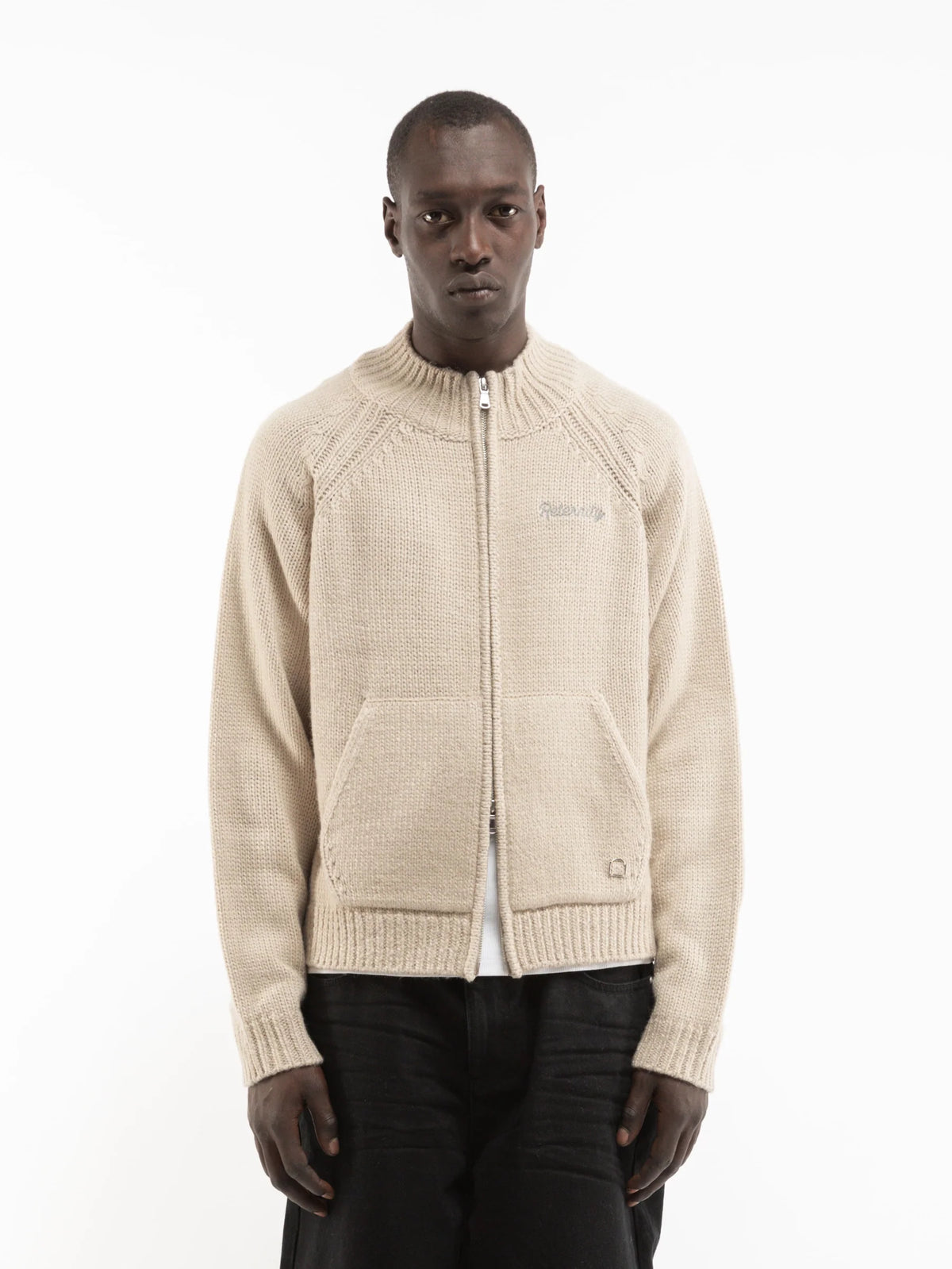 Modelo con chaqueta de punto Reternity crema y pantalón negro, vista frontal