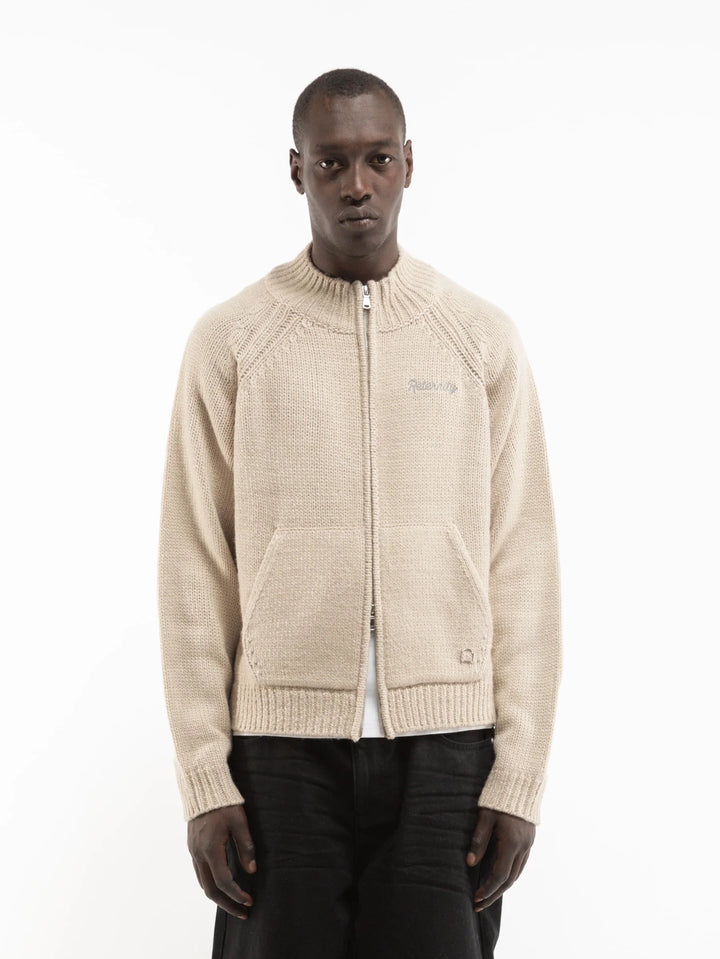 Modelo con chaqueta de punto Reternity crema y pantalón negro, vista frontal