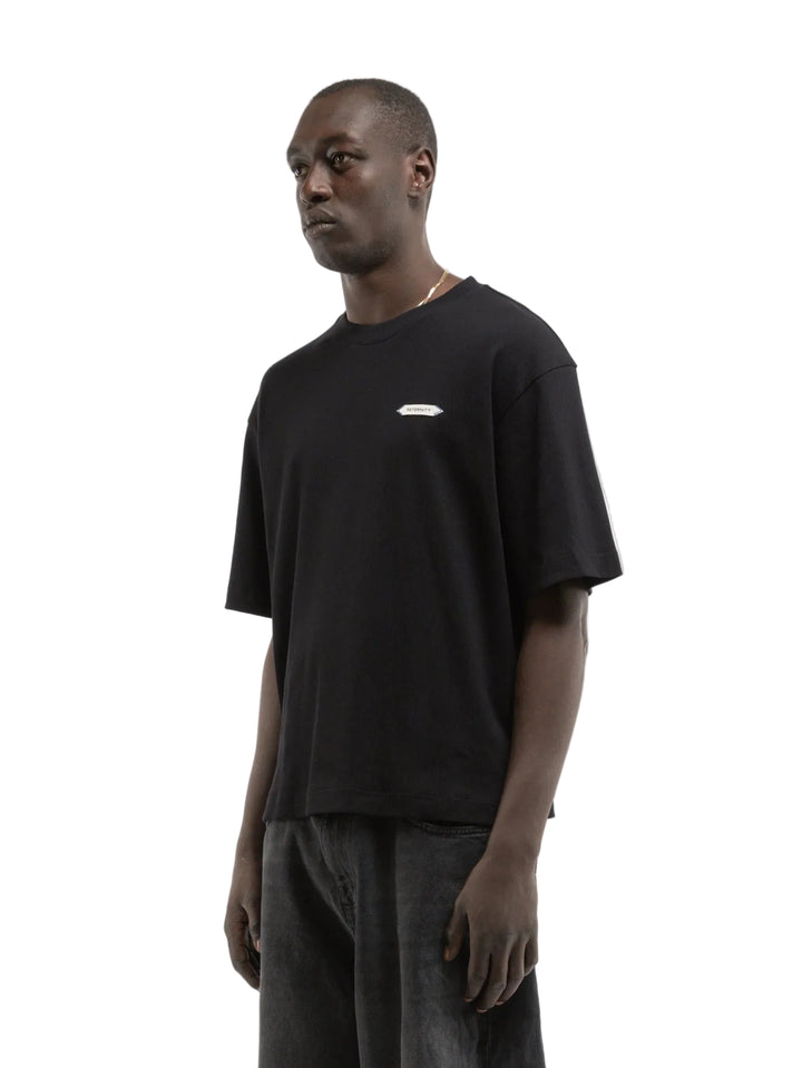Hombre con la camiseta Reternity L'Atelier Line Rib negra, plano de medio cuerpo