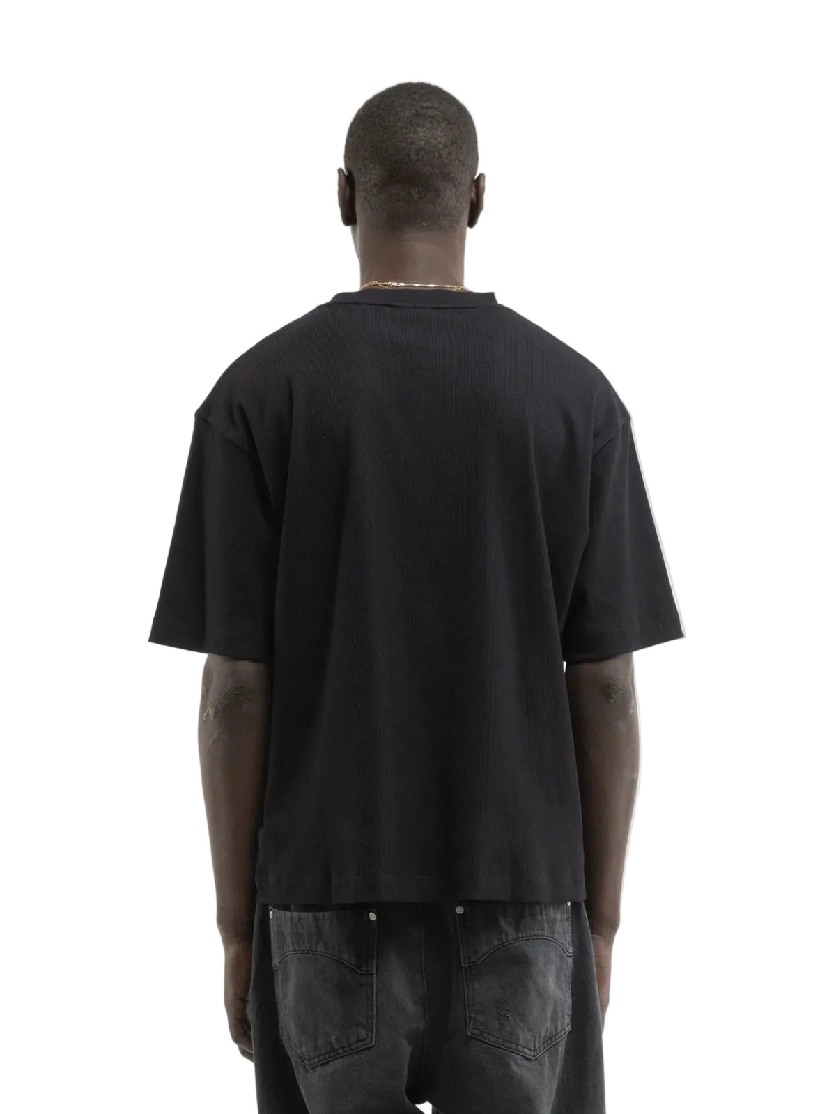 Hombre de espaldas con la camiseta Reternity L'Atelier Line Rib negra, espalda lisa, cuerpo entero