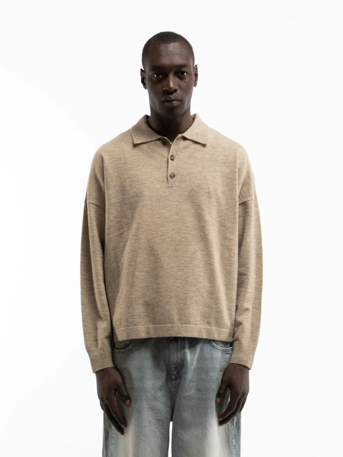 Hombre con el polo de punto Reternity Designed to Create arena de manga larga y vaqueros claros, look completo