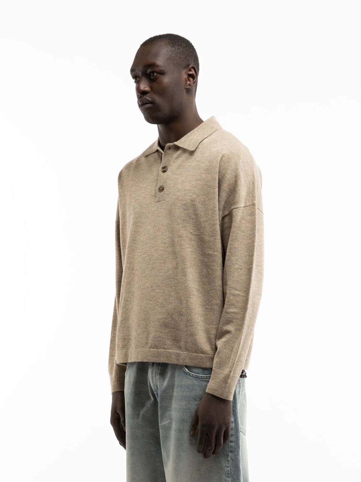 Hombre de perfil con el polo de punto Reternity Designed to Create arena, cuerpo entero