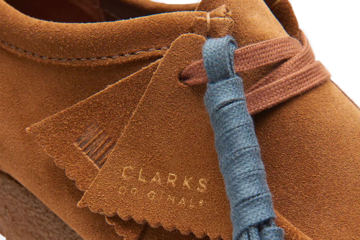 Detalle del ante marrón, los cordones y el fob de los Clarks Wallabee Cola