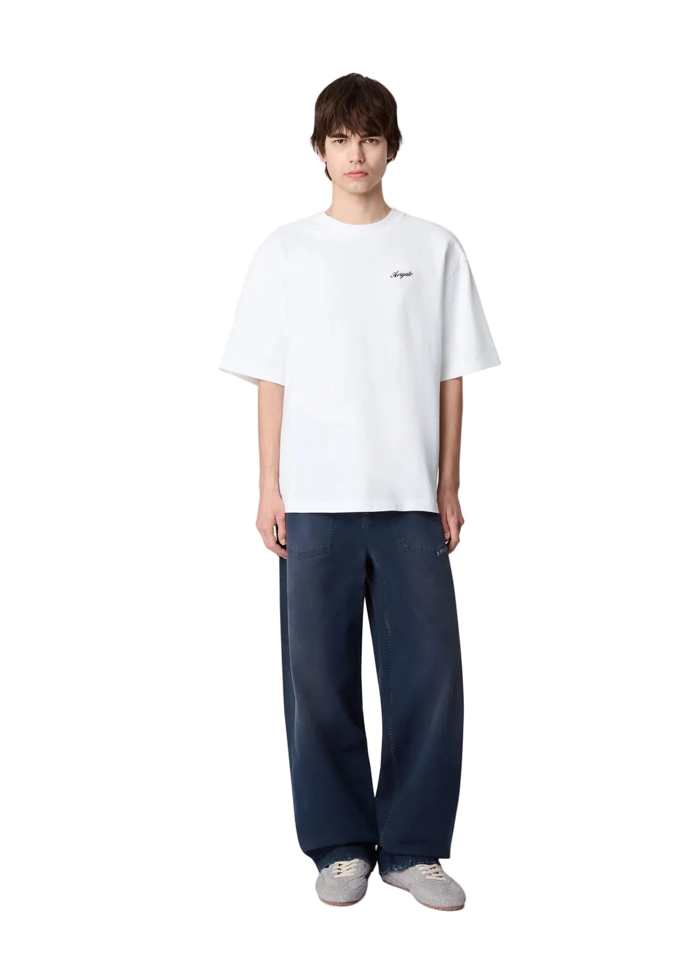 Hombre con la camiseta Axel Arigato Honor blanca oversized y pantalón azul, look completo