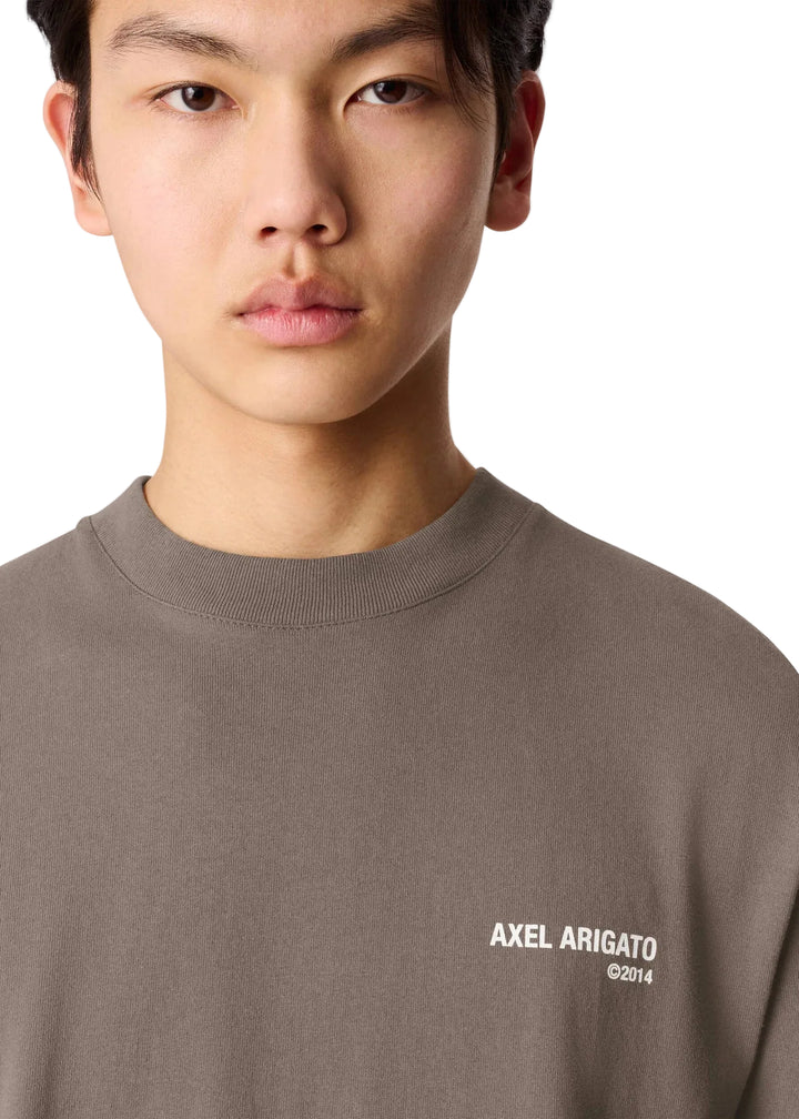 Detalle del print Axel Arigato en el pecho de la camiseta Legacy marrón