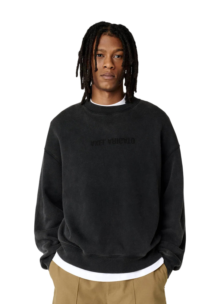 Hombre con la sudadera Axel Arigato Distort Washed negra oversized y pantalón beige, vista de frente