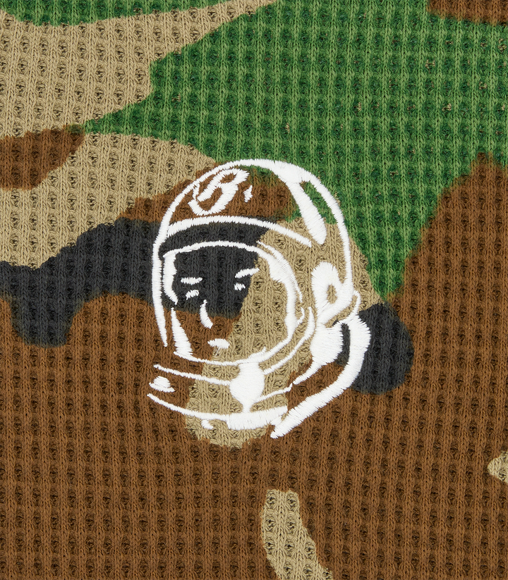 Detalle del emblema del astronauta bordado sobre el tejido waffle en camuflaje de la camiseta Billionaire Boys Club