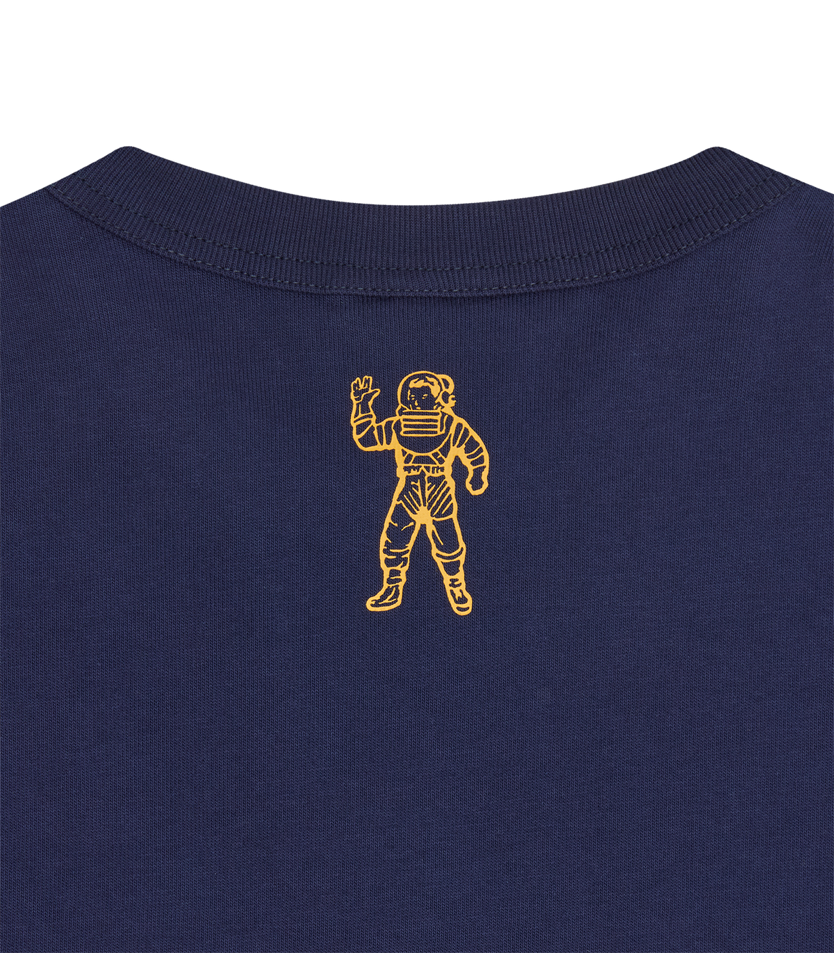 Detalle del emblema del astronauta en dorado en la parte alta de la espalda de la camiseta azul marino