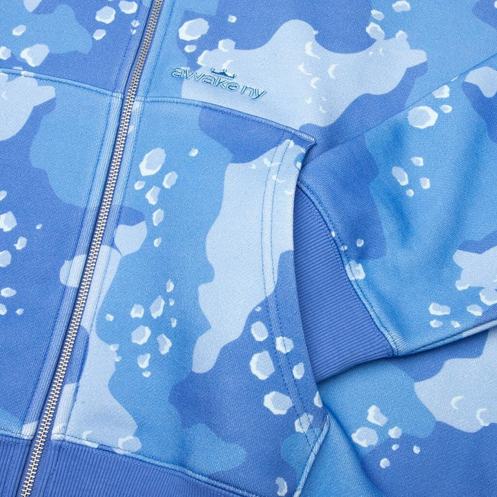 Detalle del estampado camuflaje azul y la cremallera de la sudadera Awake NY