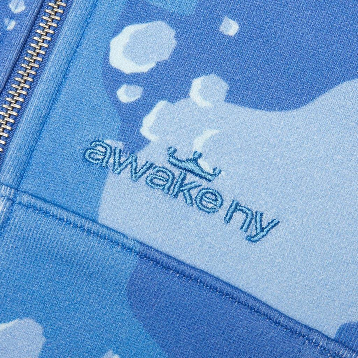 Detalle del bordado Awake NY con corona al tono sobre el camuflaje azul