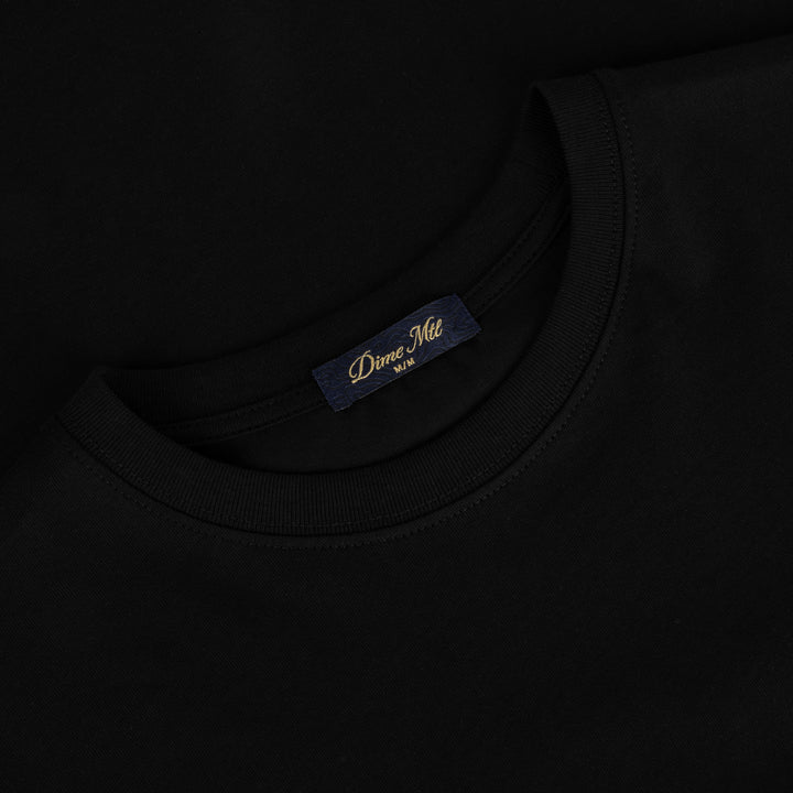 Detalle de la etiqueta interior Dime MTL en el cuello de la camiseta negra