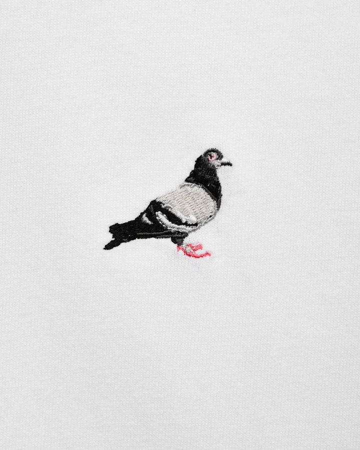 Detalle del logo Pigeon bordado en alta densidad sobre la camiseta Staple blanca