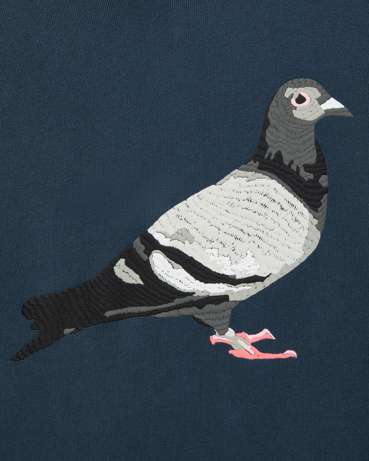 Detalle del print texturizado de alta densidad de la paloma Staple en la sudadera azul marino