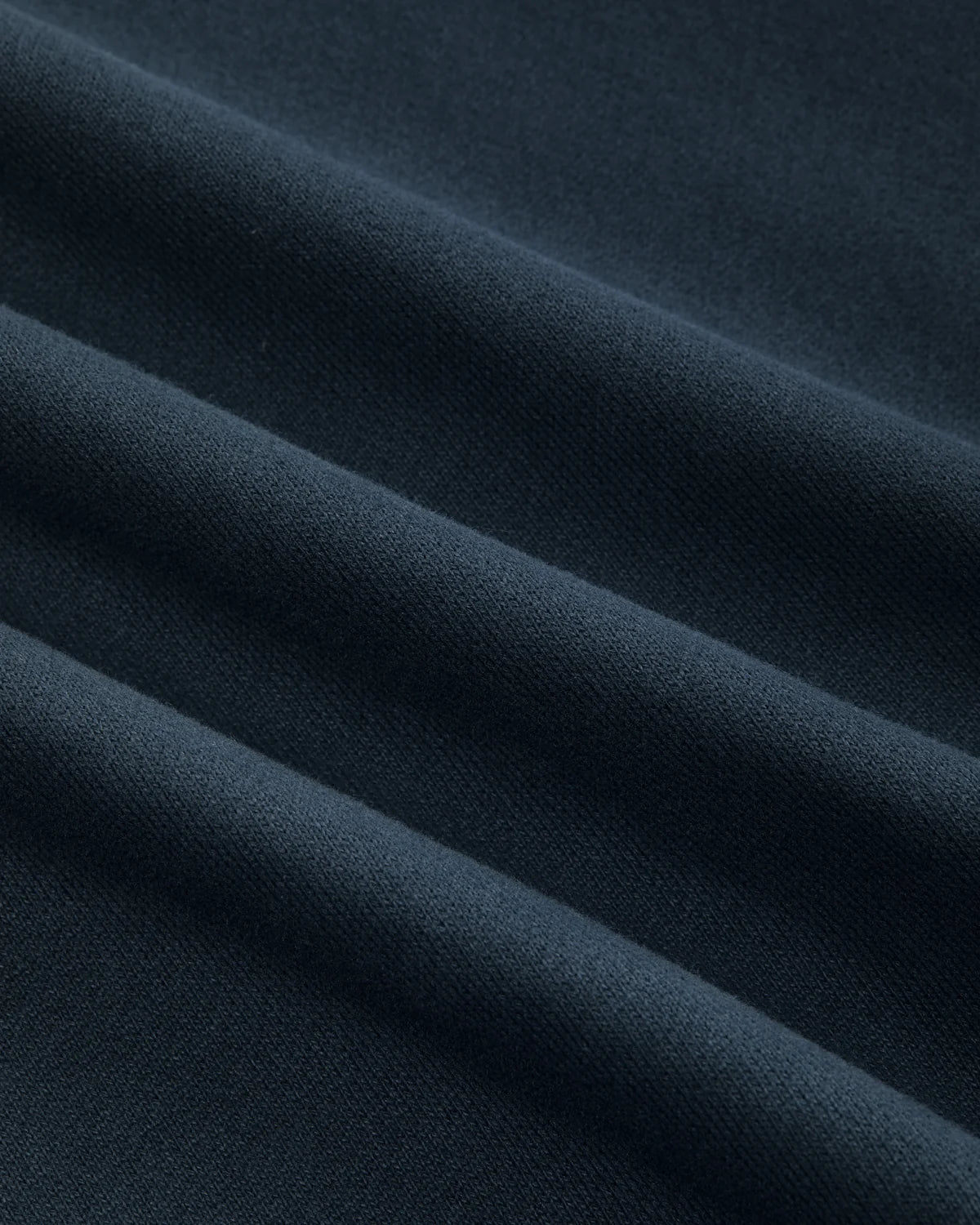 Detalle del tejido cepillado azul marino de la sudadera Staple Pigeon Logo