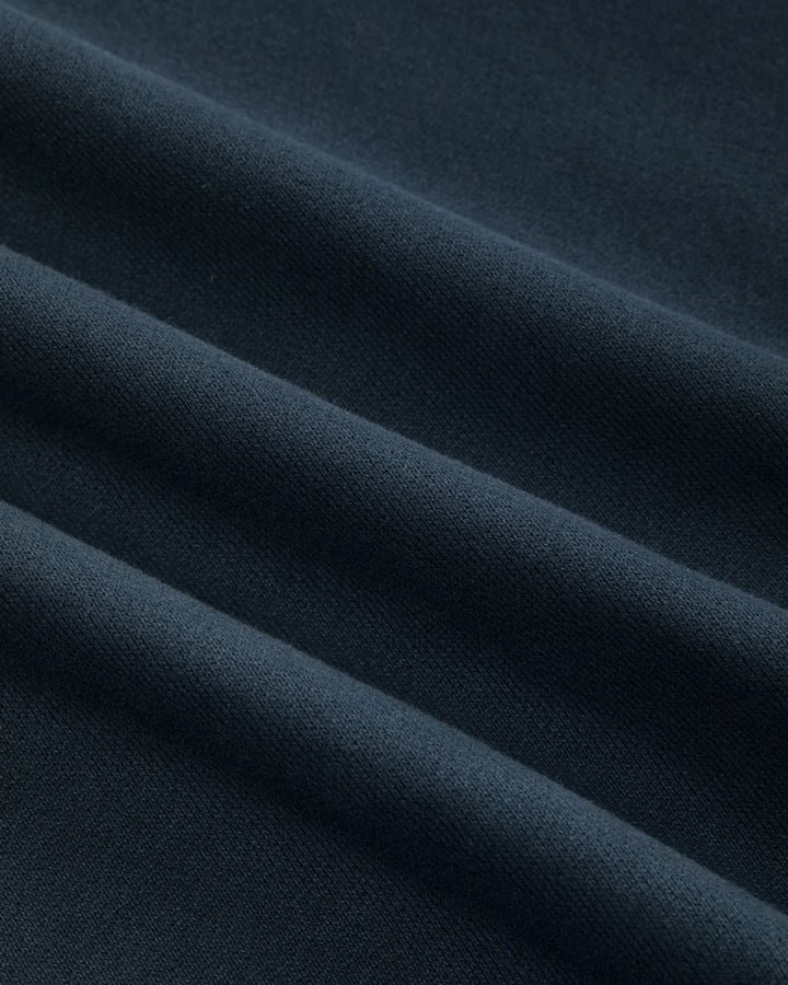 Detalle del tejido cepillado azul marino de la sudadera Staple Pigeon Logo