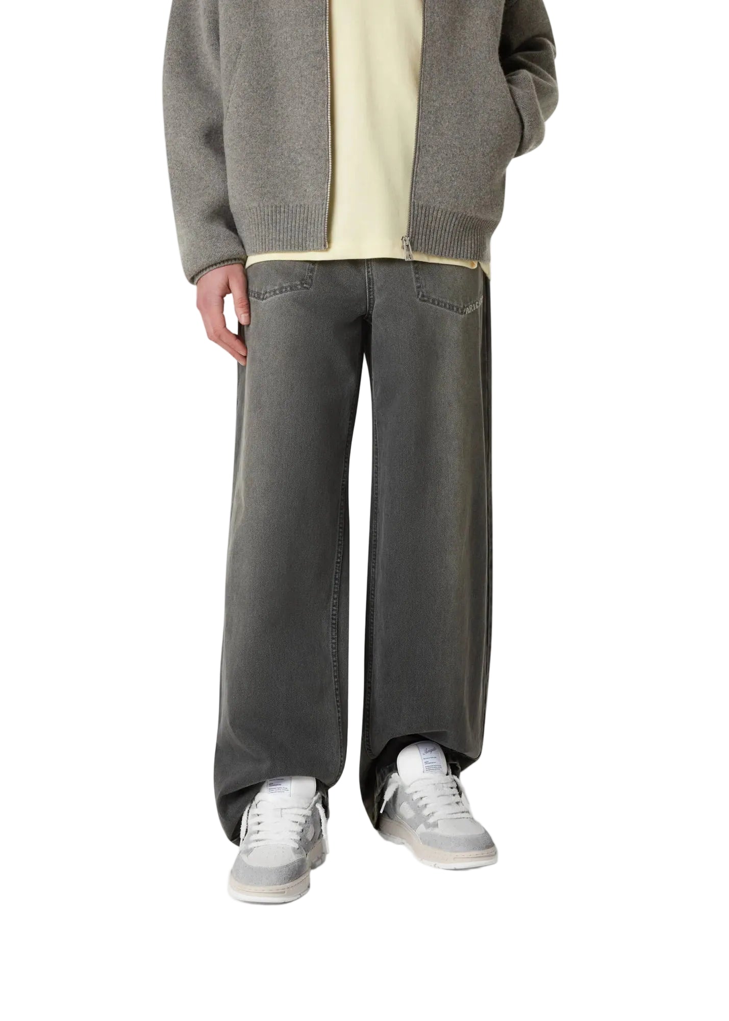  Persona con pantalón gris llevando las zapatillas Axel Arigato Area Lo Fluffy gris y blancas