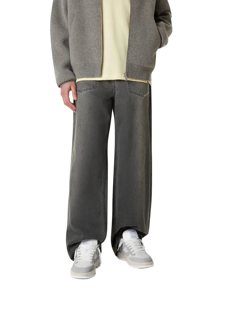  Persona con pantalón gris llevando las zapatillas Axel Arigato Area Lo Fluffy gris y blancas