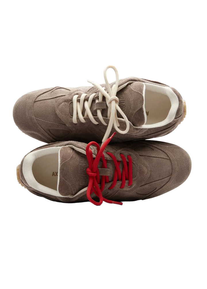 Par de zapatillas de ante marrón topo apiladas, con cordones rojos y suela de goma caramelo