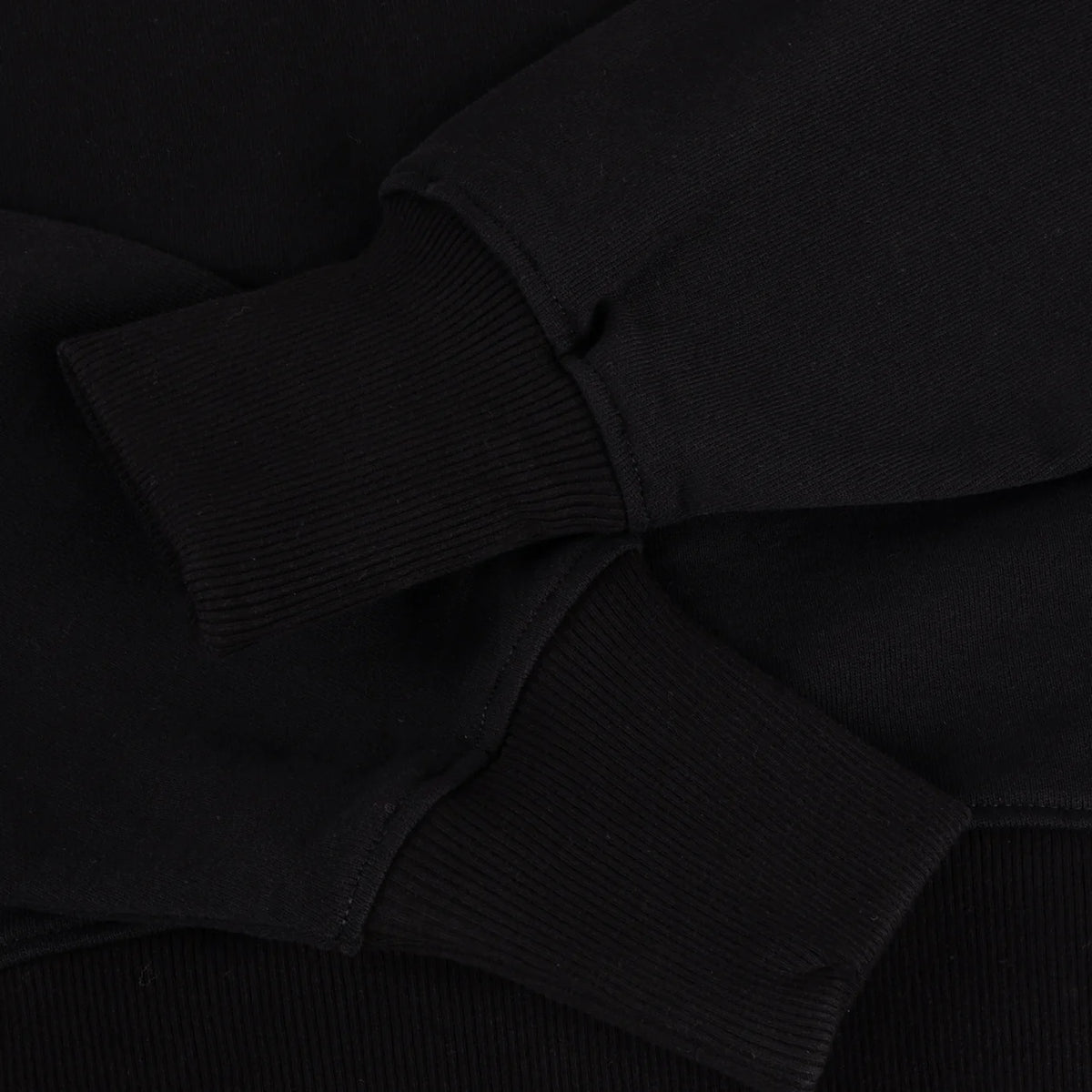 Detalle del puño y bajo en canalé de la sudadera Dime Cropped negra