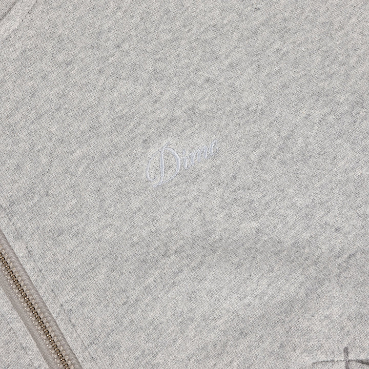 Detalle del logo Dime bordado y la cremallera metálica de la sudadera gris jaspeado