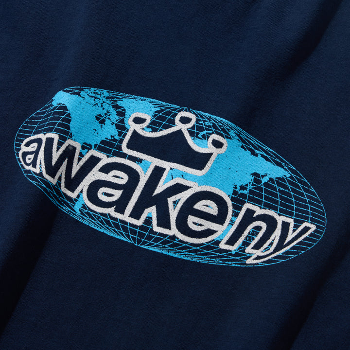 Detalle del estampado del globo terráqueo con awake ny en celeste sobre la camiseta azul marino