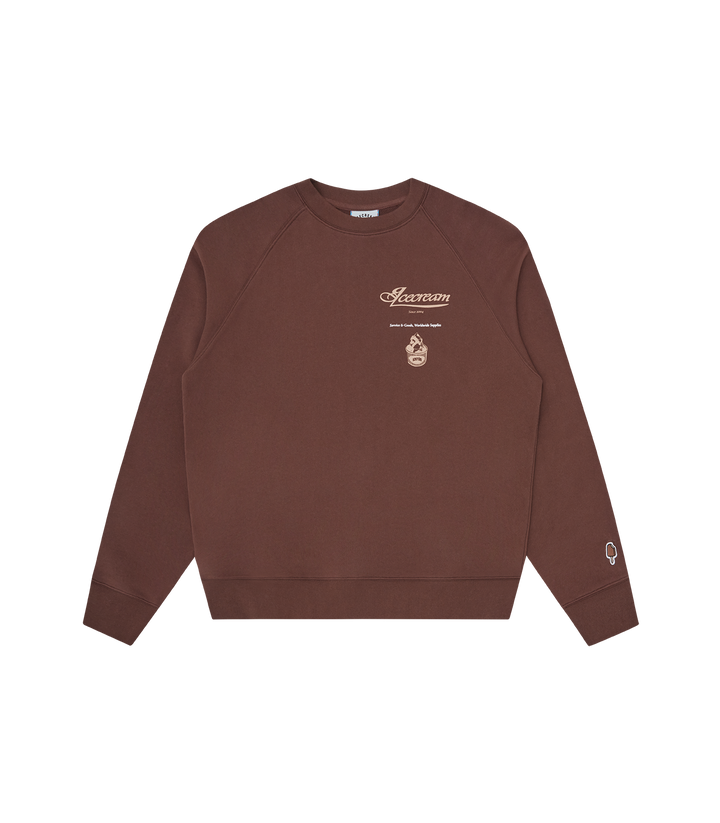 Sudadera Parlor Crewneck marrón de ICECREAM Spring 26' destaca por su estética retro y gráficos estacionales. Presenta serigrafia frontal.