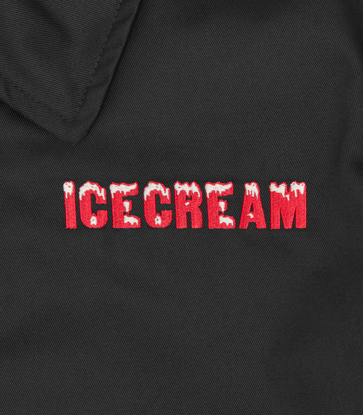 Detalle del logo ICECREAM bordado en rojo en pecho de la chaqueta negra
