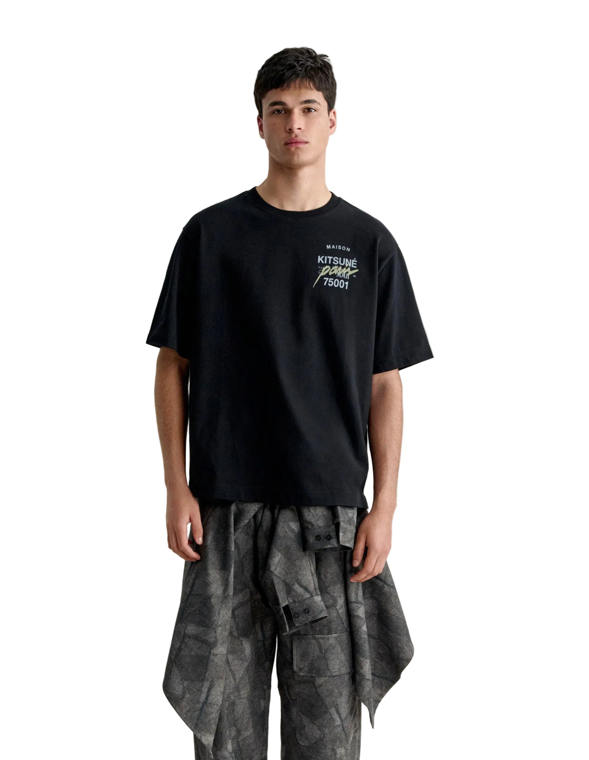 Hombre con la camiseta Maison Kitsuné MMII Profile Fox oversize negra y pantalón de camuflaje, look completo