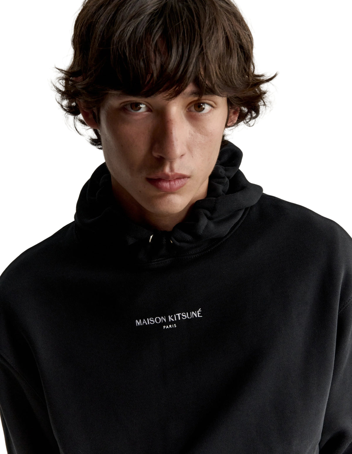 Hombre con la sudadera Maison Kitsuné Paris Comfort negra, plano de medio cuerpo con el logo en el pecho