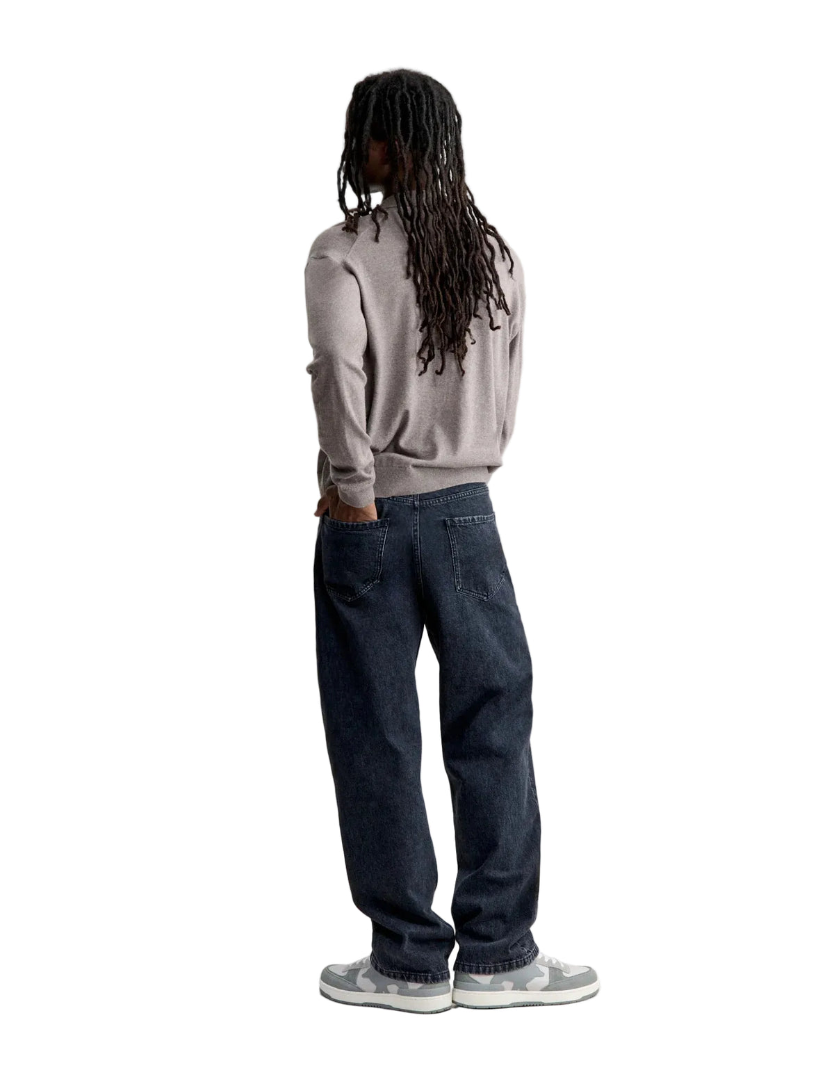 Hombre de espaldas con el polo de punto Maison Kitsuné beige y vaqueros, cuerpo entero