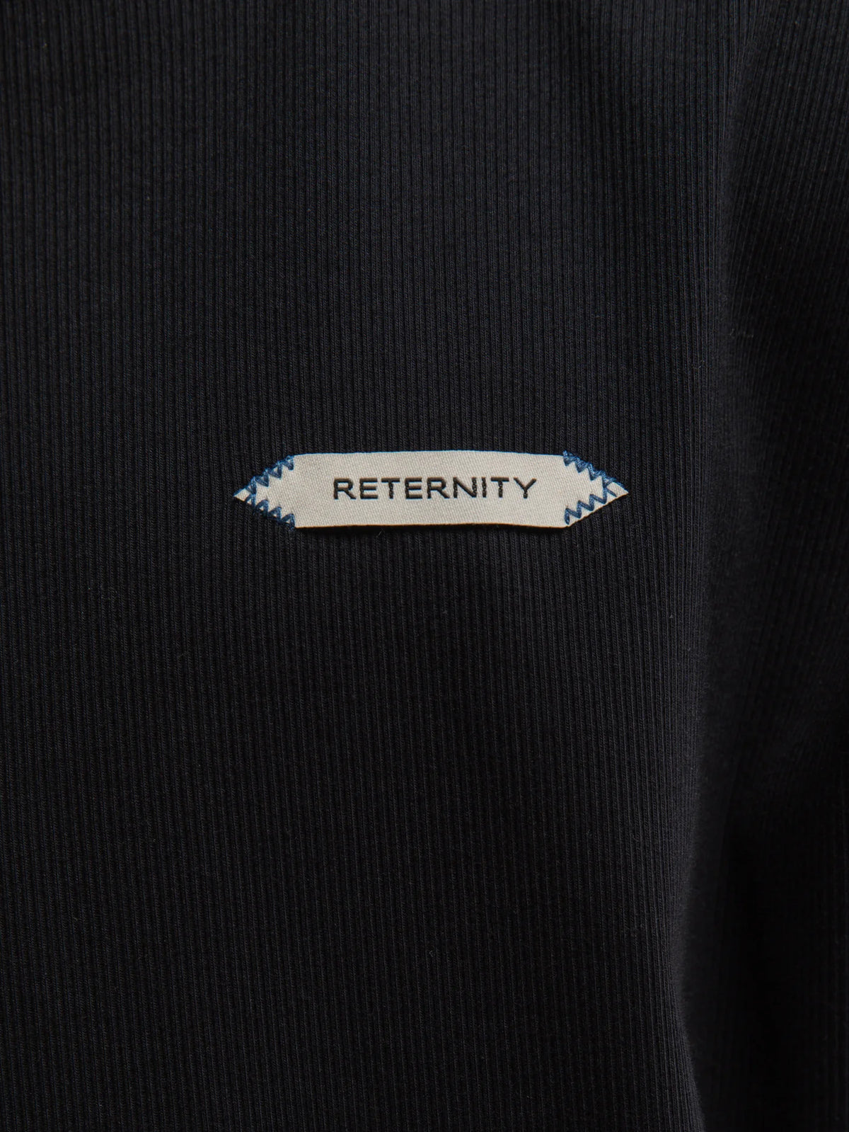 Hombre con la camiseta Reternity L'Atelier Line Rib negra, plano de medio cuerpo