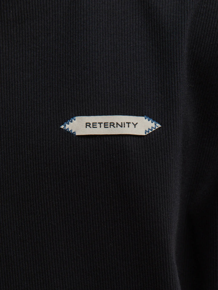 Hombre con la camiseta Reternity L'Atelier Line Rib negra, plano de medio cuerpo