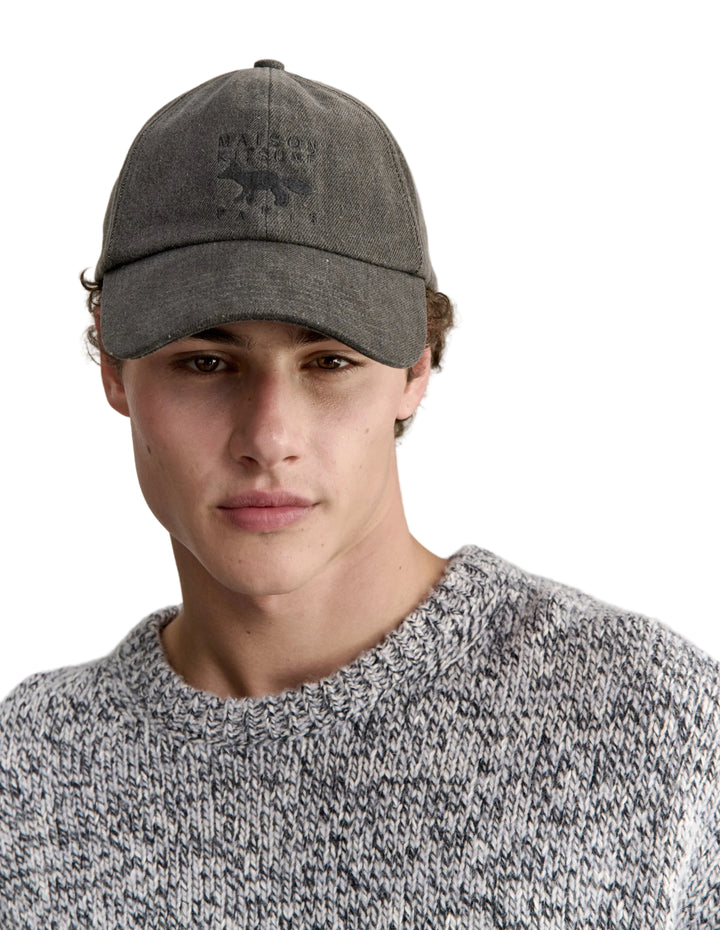 Hombre con la gorra Maison Kitsuné Profile Fox de denim gris y jersey, plano de medio cuerpo