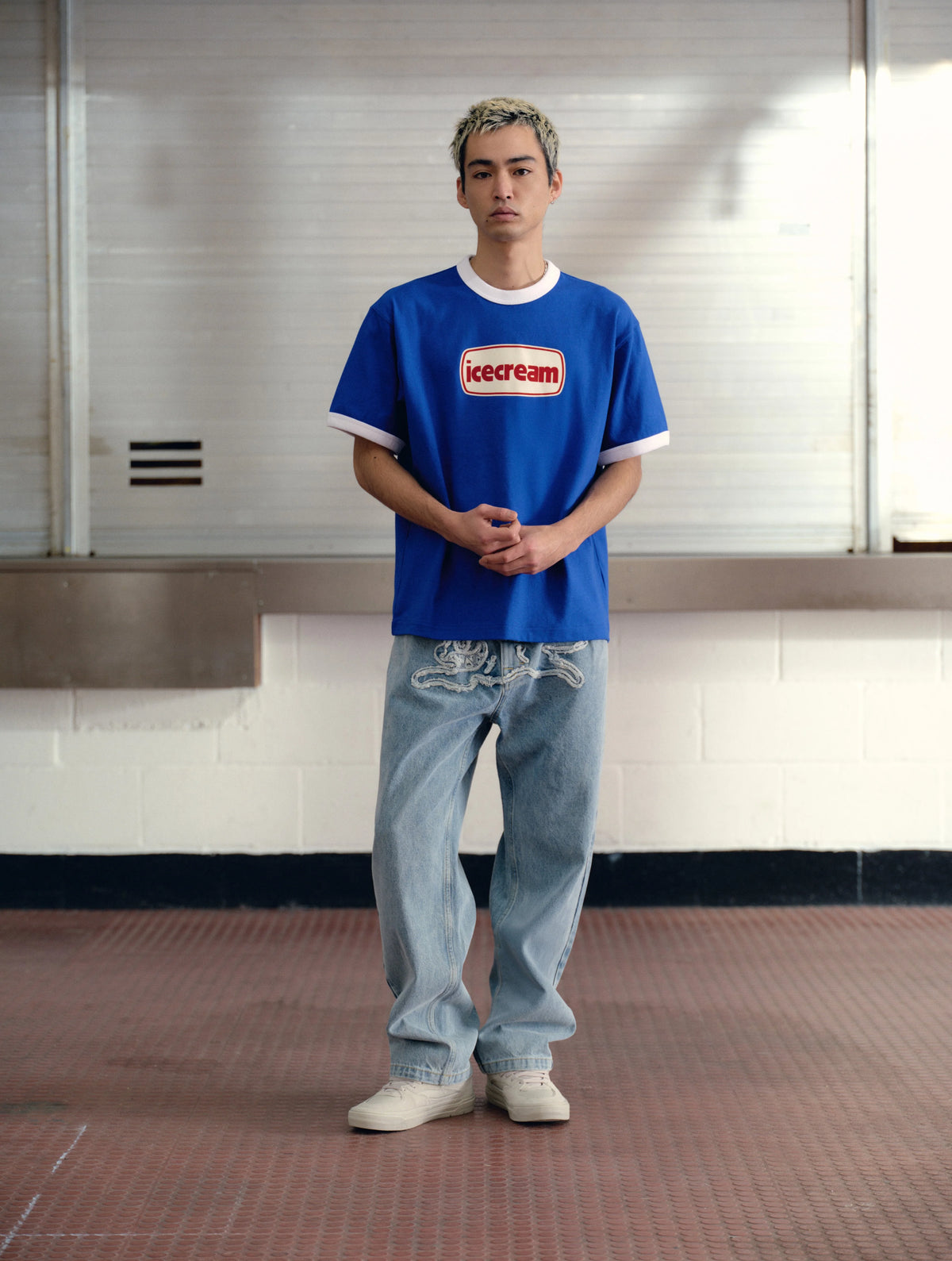 Hombre con la camiseta ICECREAM azul ringer y vaqueros claros, look completo de cuerpo entero