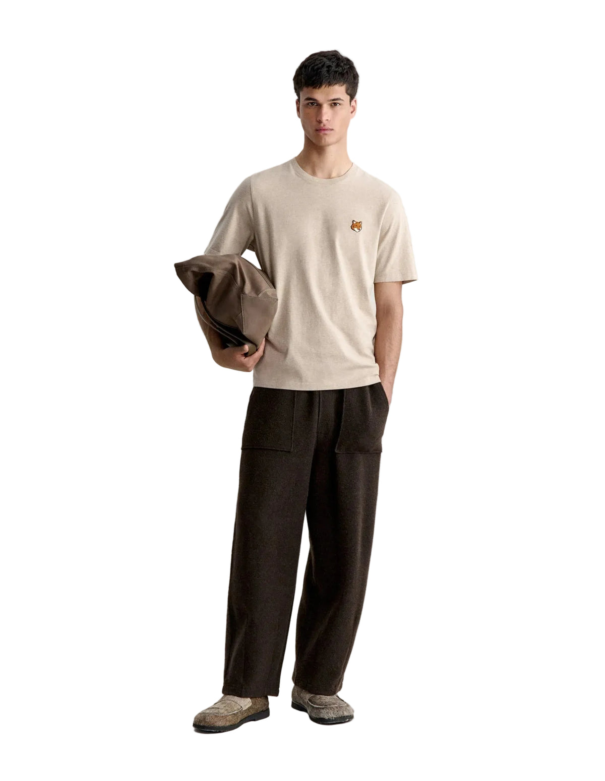 Hombre con la camiseta Maison Kitsuné Fox Head beige y pantalón marrón, look completo de cuerpo entero
