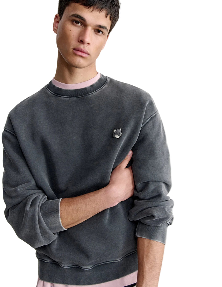 Hombre con la sudadera Maison Kitsuné Fox Head Faded gris, plano de medio cuerpo con el parche del zorro en el pecho