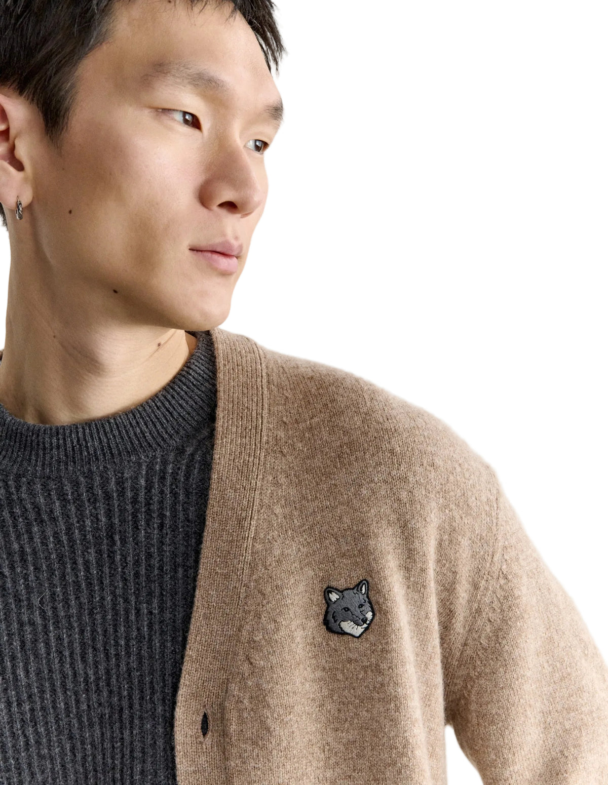Hombre con el cárdigan Maison Kitsuné Fox Head Lambswool beige, plano de medio cuerpo con el parche del zorro en el pecho