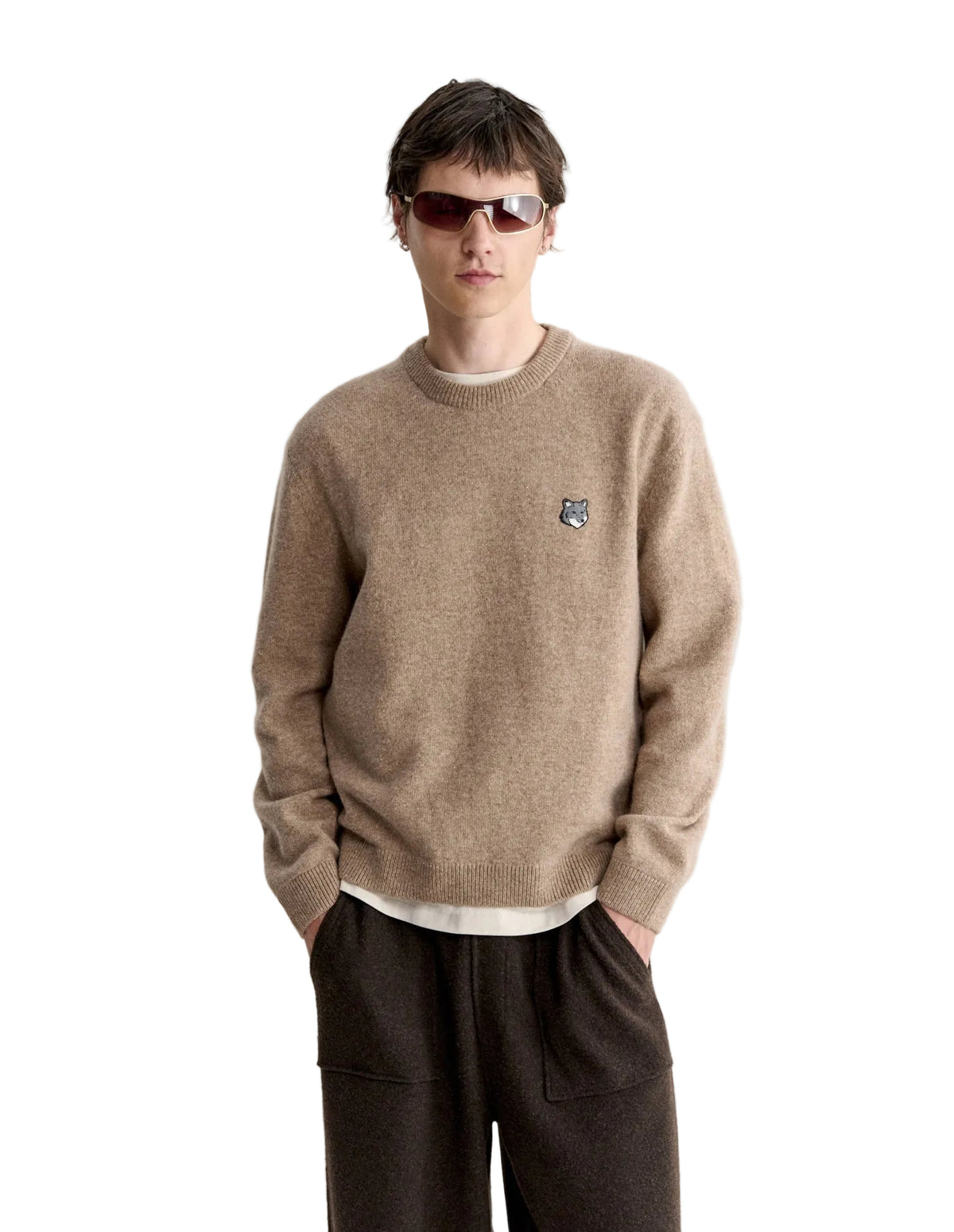 Hombre con el jersey Maison Kitsuné Fox Head Lambswool beige y pantalón oscuro, look completo de cuerpo entero