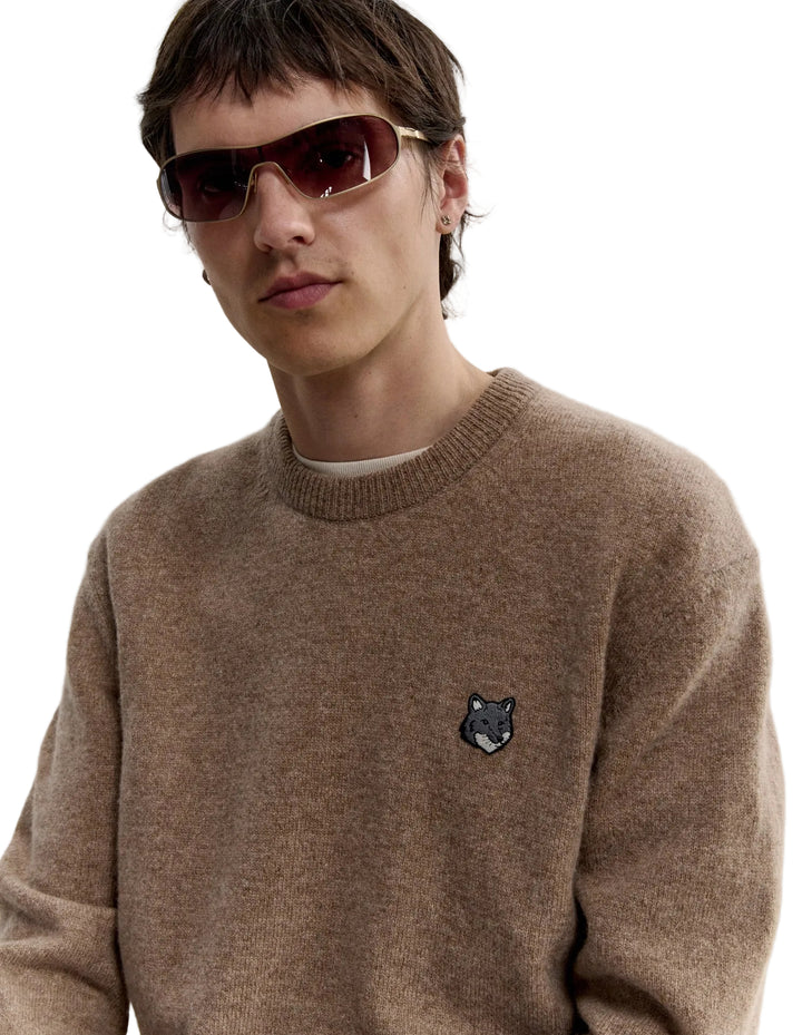 Hombre con gafas de sol y el jersey Maison Kitsuné Fox Head Lambswool beige, plano de medio cuerpo con el parche del zorro en el pecho