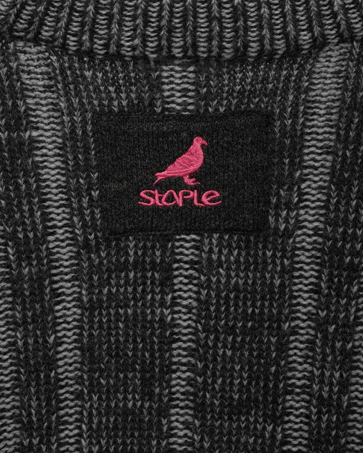 Detalle del parche Pigeon de Staple bordado en rosa en la nuca del cárdigan