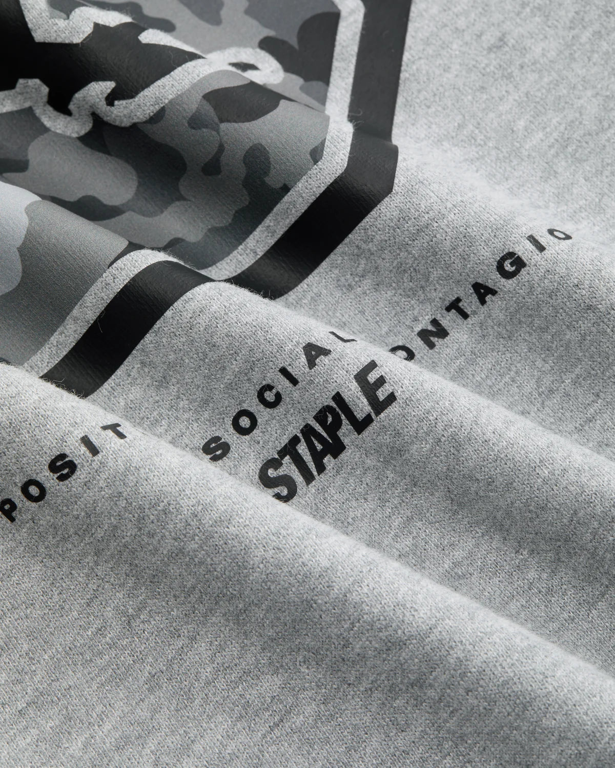 Detalle del tejido y el lettering "Staple Positive Social Contagion" de la sudadera