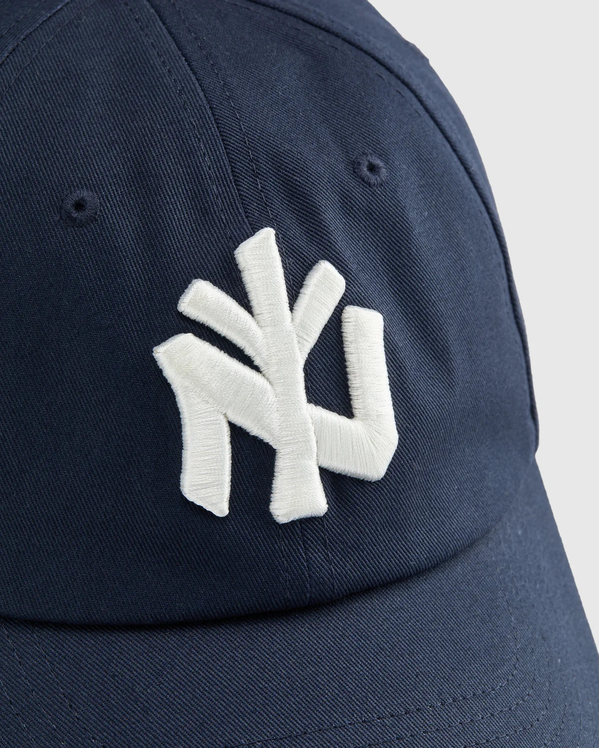 Detalle del logo NY bordado en blanco en el frontal de la gorra Staple azul marino