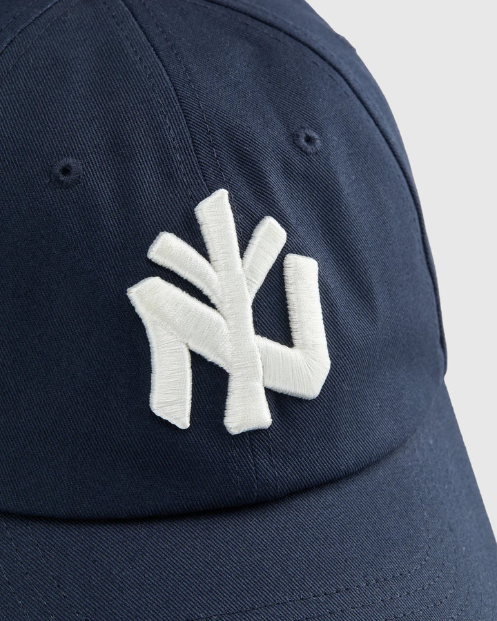 Detalle del logo NY bordado en blanco en el frontal de la gorra Staple azul marino