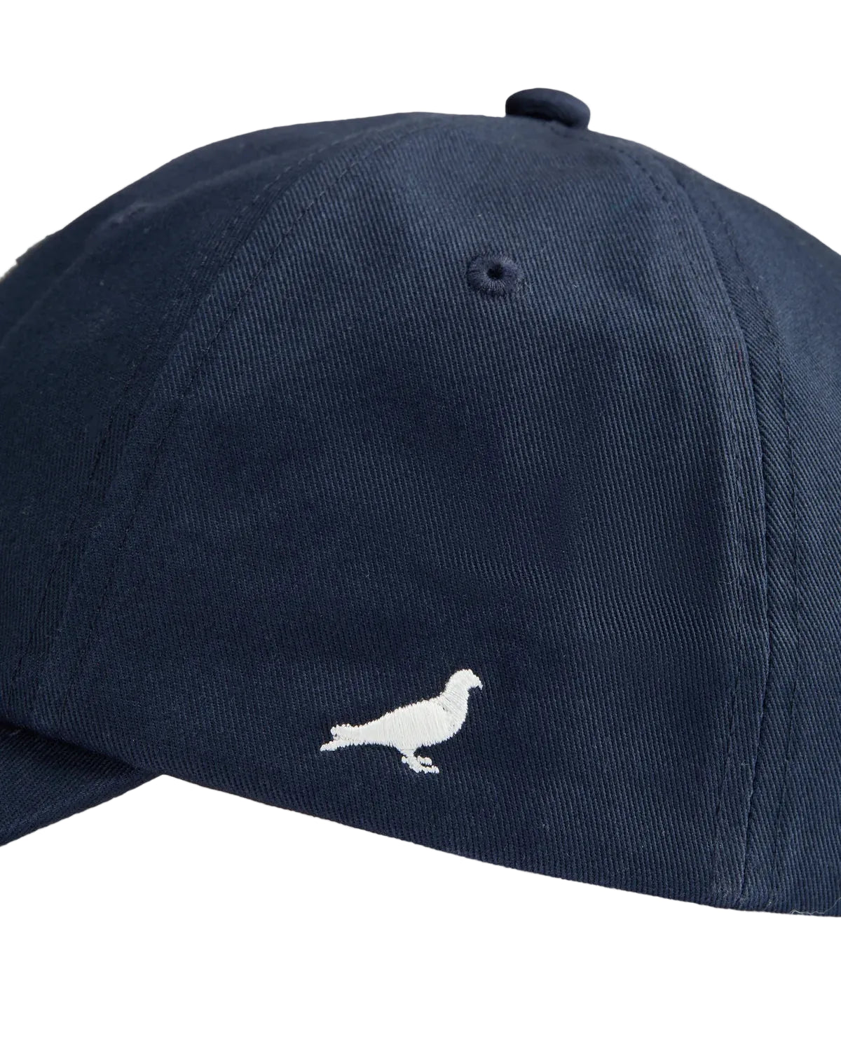 Detalle de la paloma Pigeon bordada en el lateral de la gorra Staple azul marino