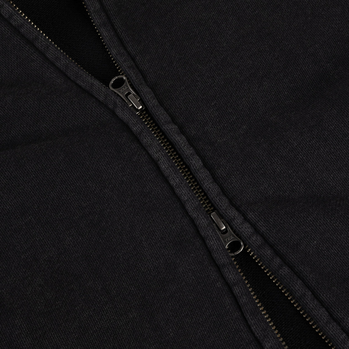 Detalle de la doble cremallera central de la sudadera Dime negra lavada