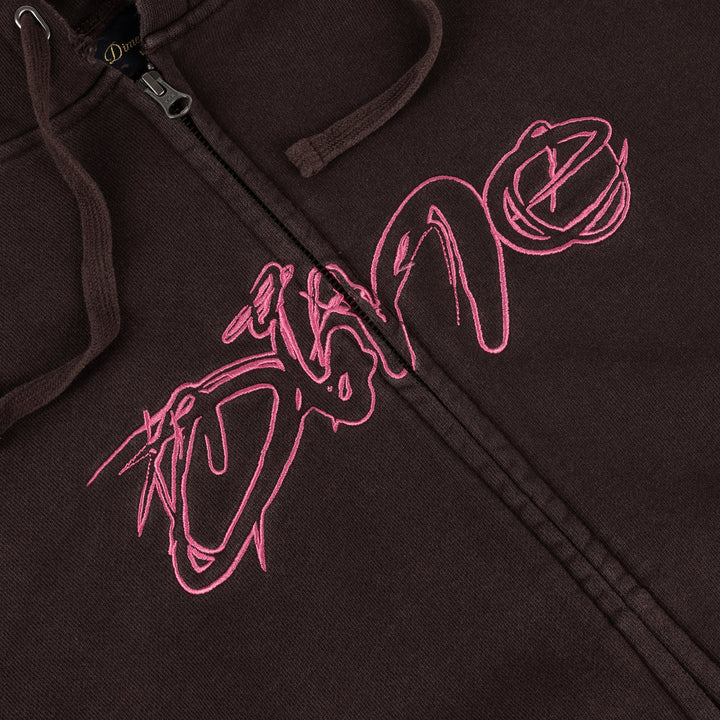 Detalle del logo Dime bordado en estilo grafiti rosa sobre la sudadera marrón lavada