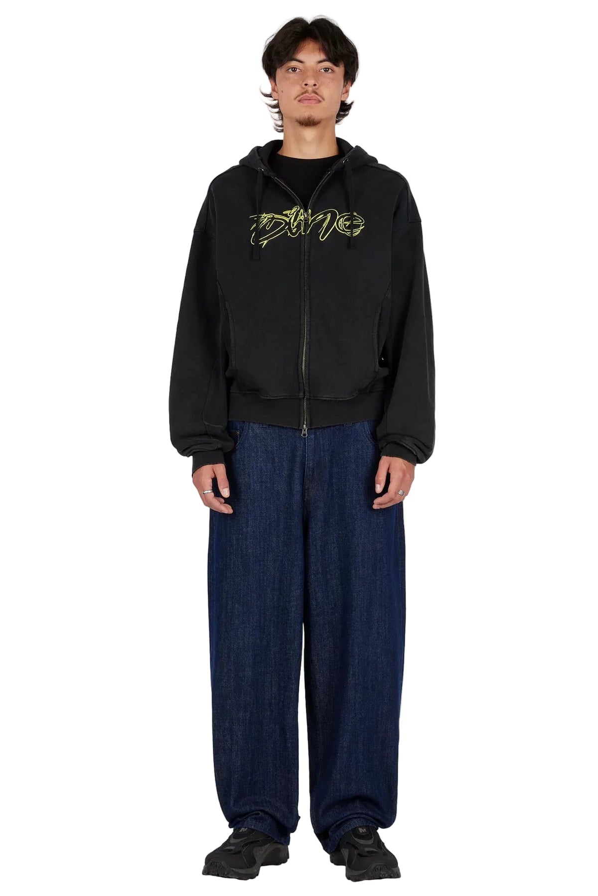 Modelo con sudadera Dime Distressed Terry Zip Hoodie negra y pantalón ancho azul, vista frontal